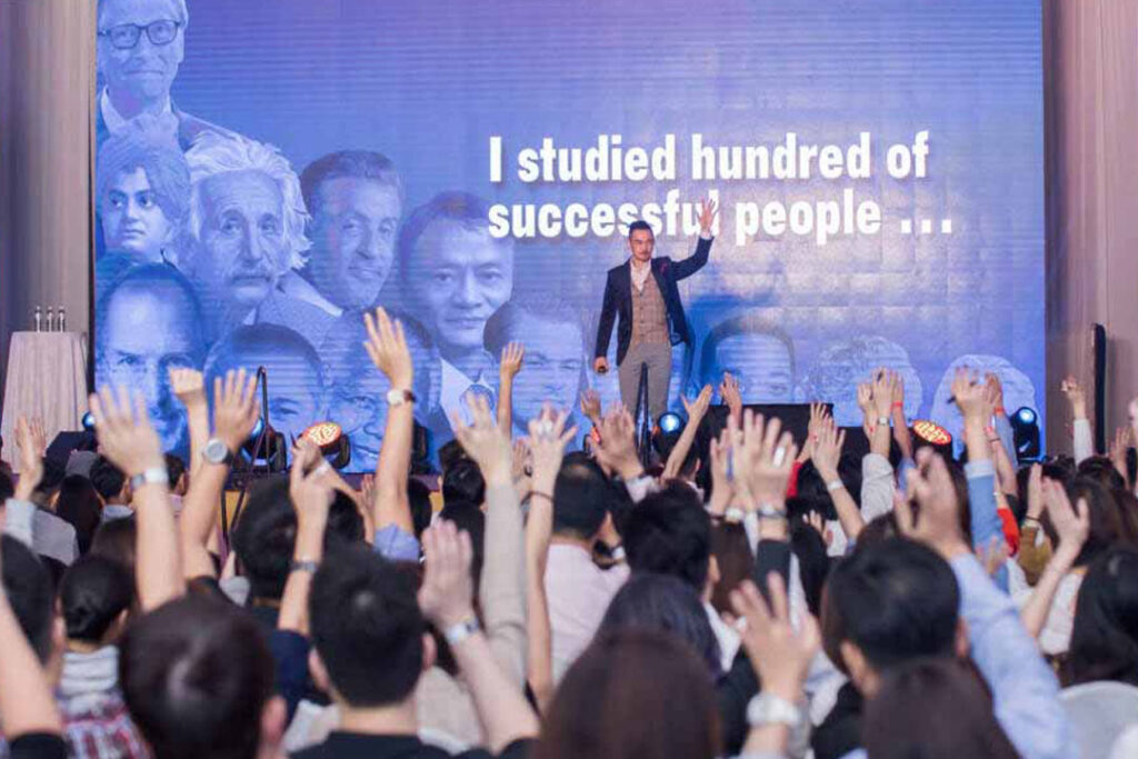 Brian On Stage with Audience Hands Raised Together